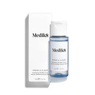 Medik8 Press & Glow tonic bottle stands in front of its matching white product carton on a clean white background. Text on both identifies the product as a travel sized Daily Exfoliating PHA Tonic with Enzyme Activator. 