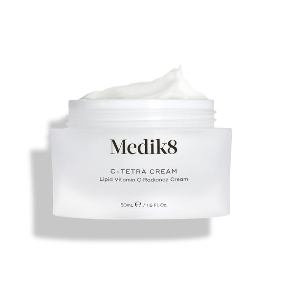 Medik8 C-Tetra Cream jar displayed open against a clean white background with soft shadows. The white, frosted-glass jar features the Medik8 logo and is labeled  C-TETRA CREAM Lipid Vitamin C Radiance Cream  in a 50mL size. A thick swirl of white cream is visible on top of the jar, highlighting its moisturising texture.-8