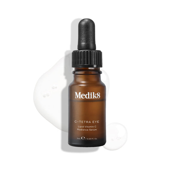 Medik8 C-Tetra Eye Lipid Vitamin C Radiance Serum bottle displayed on a white background with translucent serum droplets, highlighting its liquid texture.-48
