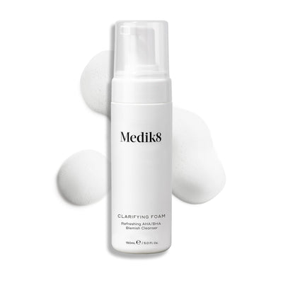 Medik8 Clarifying Foam pump bottle displayed on a clean white background with three dollops of white airy foam. Text identifies it as a Refreshing AHA/BHA Blemish Cleanser in a 150mL size.