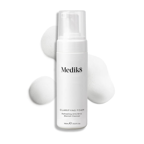 Medik8 Clarifying Foam pump bottle displayed on a clean white background with three dollops of white airy foam. Text identifies it as a Refreshing AHA/BHA Blemish Cleanser in a 150mL size.-3