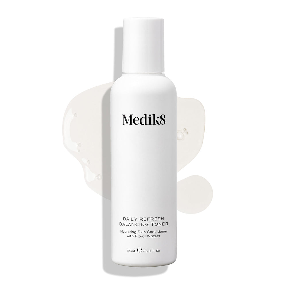 Medik8 Daily Refresh Balancing Toner bottle stands on a white background with a clear liquid spill. Text identifies it as a  Hydrating Skin Conditioner with Floral Waters  in a 150mL size.