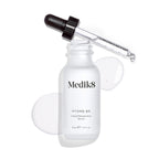 Medik8 Hydr8 B5 serum bottle stands against a clean white background with a clear liquid puddle and droplets, with the dropper resting on top. Text identifies the product as a 30mL  Liquid Rehydration Serum. 