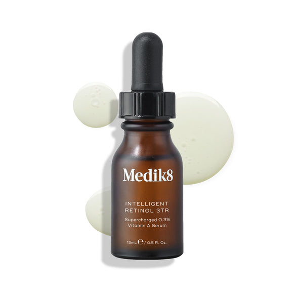 Medik8 Intelligent Retinol 3TR serum bottle stands against a clean white background with three clear liquid droplets. Text identifies the product as a 15mL  Supercharged 0.3% Vitamin A Serum. -4