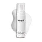 Medik8 Micellar Mousse pump bottle displayed on a white background with a smear of white foam behind it, highlighting the product's texture.