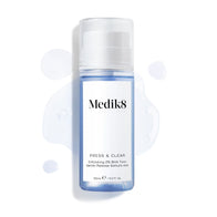 Medik8 Press & Clear bottle (150ml) displayed on a white background with splashes of blue tonic around it. Text highlights the  Exfoliating 2% BHA Tonic  formula.