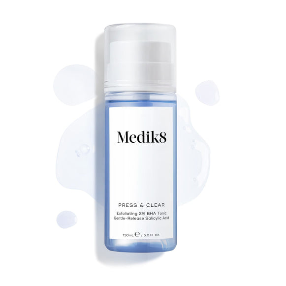 Medik8 Press & Clear bottle (150ml) displayed on a white background with splashes of blue tonic around it. Text highlights the  Exfoliating 2% BHA Tonic  formula.-4