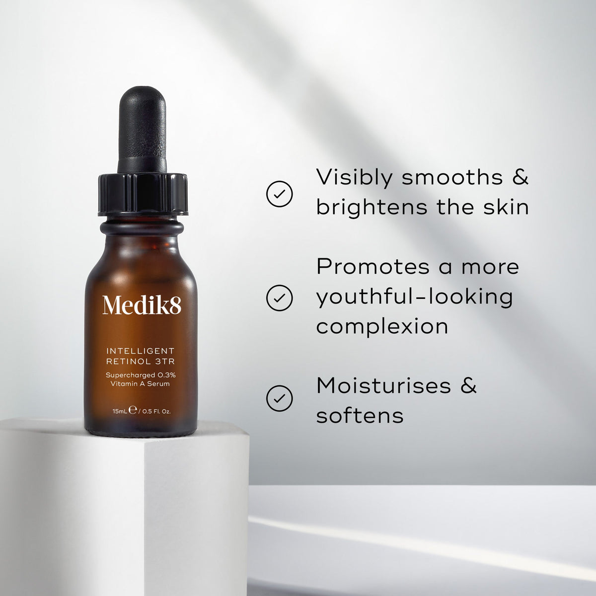 Medik8 Intelligent Retinol 3TR serum bottle stands on a white pedestal against a bright, neutral background. Text highlights that the product  Visibly smooths & brightens the skin,   Promotes a more youthful-looking complexion,  and  Moisturises & softens. 