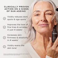 "Close-up of a person's face being treated with a glass pipette, set against a light grey background. Text states the product is  CLINICALLY PROVEN ACTION ON 4 SIGNS OF SUN AGEING*  followed by four check-marked claims:

Visibly reduces dark spots & age spots*

Improves the look of fine lines & wrinkles in just 4 weeks*

Increases skin firmness & elasticity in 4 weeks*

Visibly evens the skin tone*

A footer note specifies these results are proven via an independent clinical study conducted over 12 weeks on