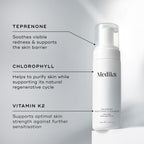 A Medik8 Calmwise Soothing Cleanser bottle displayed on a white block. Lines connect the bottle to text explaining key ingredients:  Teprenone  to soothe redness,  Chlorophyll  to purify skin, and  Vitamin K2  to support skin strength.
