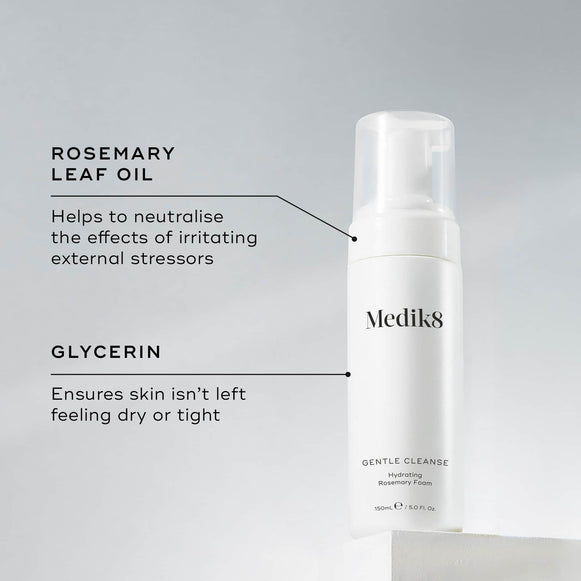A Medik8 Gentle Cleanse bottle displayed on a white block. Lines connect the bottle to text explaining key ingredients: "Rosemary Leaf Oil" to neutralise the effects of irritating external stressors and "Glycerin" to ensure skin isn't left feeling dry or tight.-hover-10