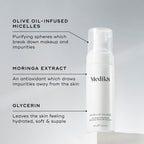 A Medik8 Micellar Mousse bottle displayed on a white block. Lines connect the bottle to text explaining key ingredients:  Olive Oil-Infused Micelles  to break down makeup,  Moringa Extract  to draw out impurities, and  Glycerin  for hydration.