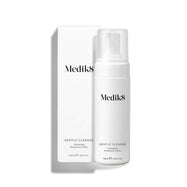 A Medik8 Gentle Cleanse pump bottle standing next to its white packaging box on a white background. Text on the bottle identifies it as a  Hydrating Rosemary Foam. 