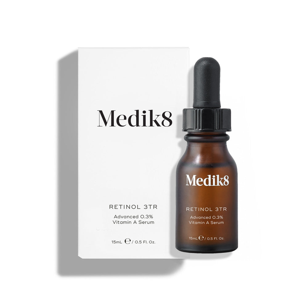 Medik8 Retinol 3TR serum bottle and its white cardboard carton displayed on a clean white background with soft shadows. The amber glass bottle with a black dropper cap and the white box both feature the Medik8 logo and identify the product as  RETINOL 3TR Advanced 0.3% Vitamin A Serum  in a 15mL size.