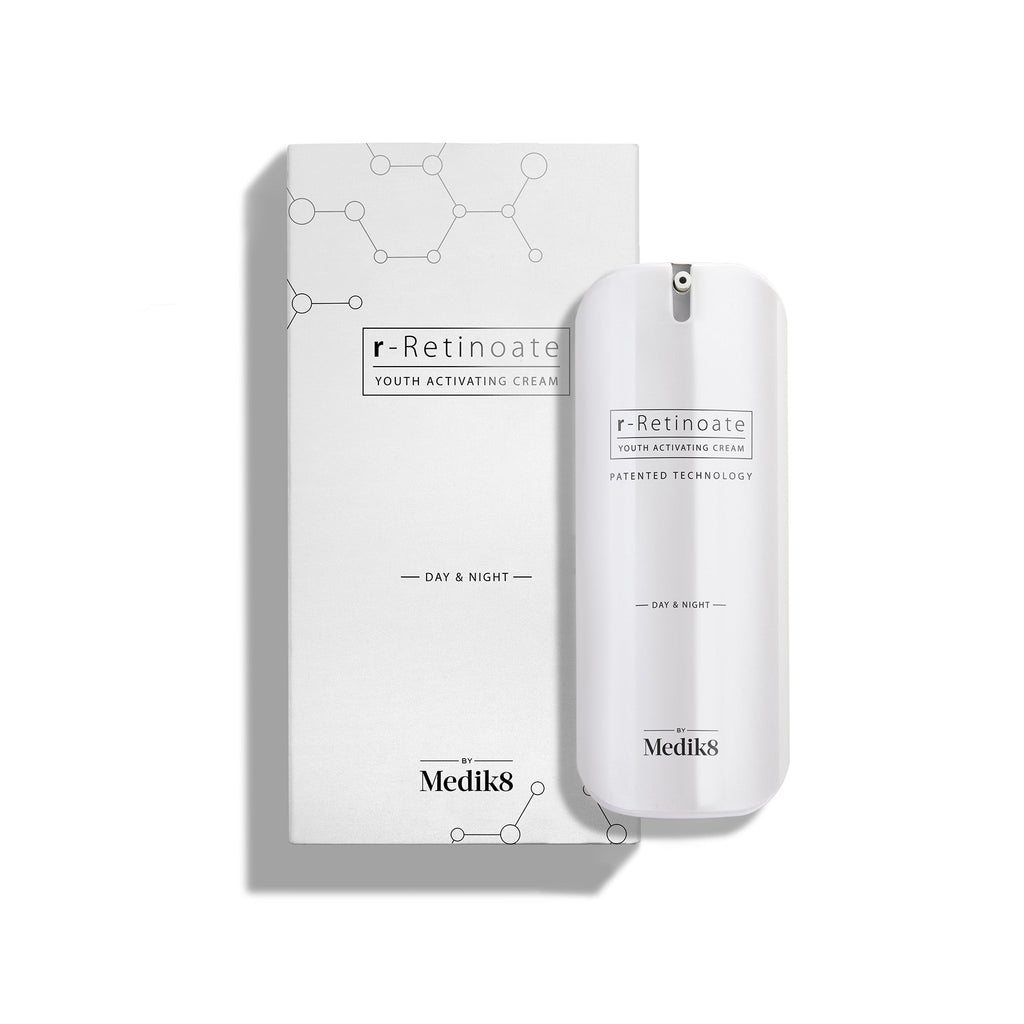 A sleek white pump bottle of r-Retinoate Day & Night stands beside its matching white carton