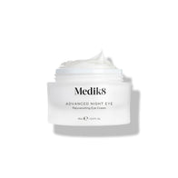 Medik8 Advanced Night Eye cream jar stands against a white background with the lid removed. The rich white cream is visible inside the jar, highlighting its texture.