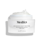 Medik8 Advanced Night Restore cream jar shown open with a rich dollop of white cream peaked on top against a clean white background, highlighting its smooth, restorative texture. Black text on the jar reads  Rejuvenating Multi-Ceramide Night Cream .