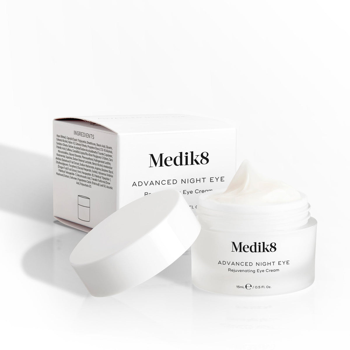 Medik8 Advanced Night Eye cream jar sits open next to its packaging box on a white background. Text highlights the  Rejuvenating Eye Cream  formula and 15mL size.