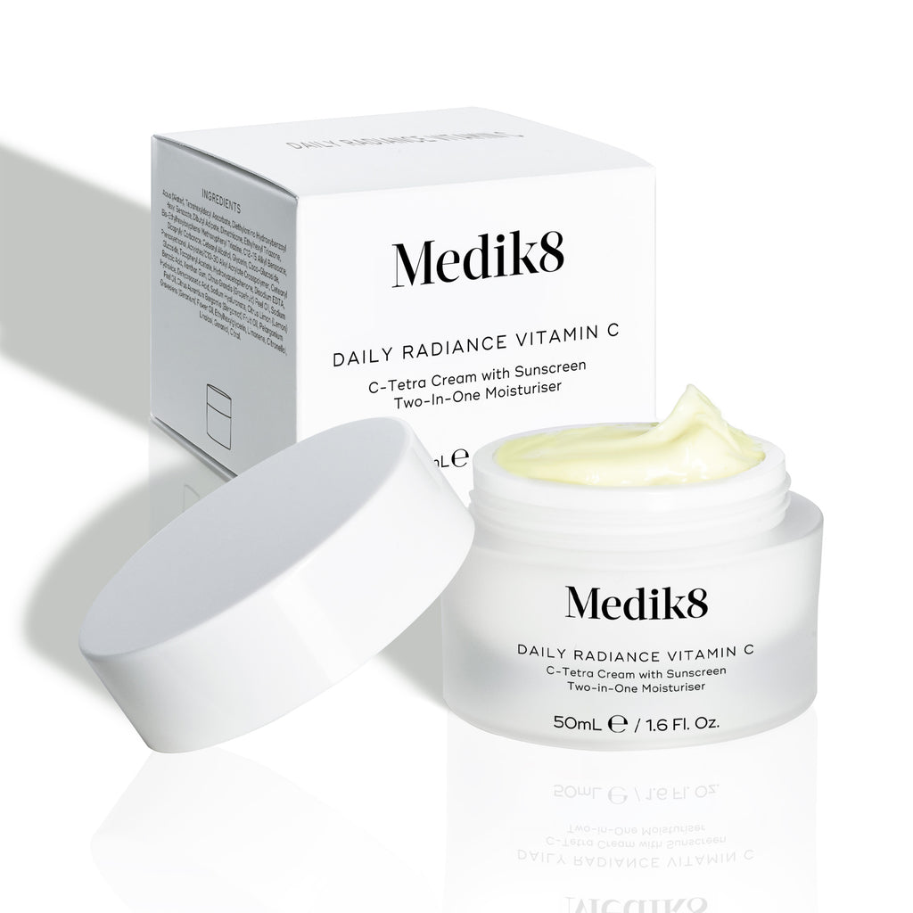 Medik8 Daily Radiance Vitamin C cream jar is shown open with a generous peak of pale yellow cream on top and it's carton packaging on the side. Text identifies the product as a 50mL C-Tetra Cream Two-in-One Moisturiser.