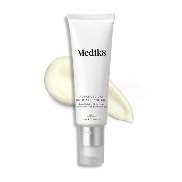 A white tube of Advanced Day Ultimate Protect stands upright, with a swipe of light cream next to it.-2