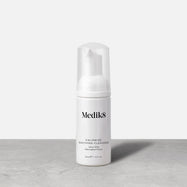 A travel-size pump bottle (40ml) of Medik8 Calmwise Soothing Cleanser displayed on a grey surface. Text describes it as an  Ultra-Mild Chlorophyll Foam. 