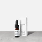 Medik8 Intelligent Retinol 6TR serum bottle stands next to its matching white product carton on a grey textured surface against a neutral background. Text on the 4mL bottle identifies it as a  Supercharged 0.6% Vitamin A Serum. 