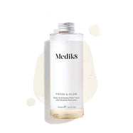 A 200mL clear refill bottle of Medik8 Press & Glow exfoliating tonic featuring a silver screw cap. Set against a white background, the bottle sits amidst a puddle and droplets of the pale yellow tonic, showcasing its liquid texture. The label text reads ""Daily Exfoliating PHA Tonic with Enzyme Activator."""