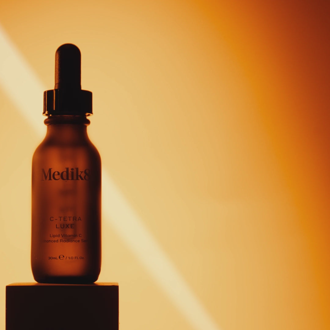A video for Medik8 C-Tetra Luxe serum featuring an amber dropper bottle and a woman with glowing skin. Text highlights include "2x more Vitamin C than our original C-Tetra" and "14% Vitamin C in a nourishing oil." The video states it is clinically proven to instantly boost skin radiance, visibly reduce wrinkles, and reduce dark spots, with "86% agree it’s the best Vitamin C serum."