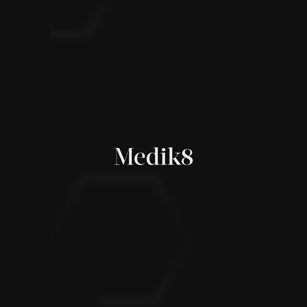 A jar of Medik8 Advanced Pro-Collagen+ Peptide Cream is featured against a sleek black background with a stylized DNA helix graphic. The video shows the cream being applied to a participant’s face, with text stating it helps to increase collagen production by 45%. A before-and-after side-by-side comparison demonstrates visibly smoother wrinkles after 7 days. High-tech graphics highlight key ingredients: Growth Factor MiniProtein™ and NAD+ Longevity Booster. The video ends with a close-up of the smooth cream